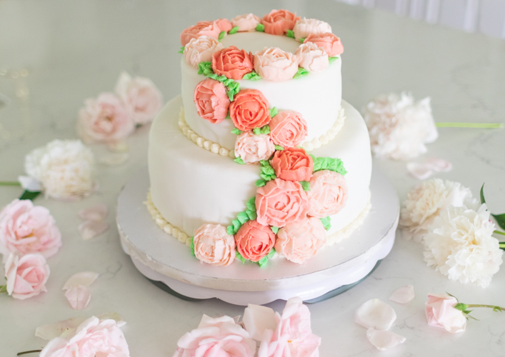If you've wanted to learn how to make buttercream flowers, here is a detailed tutorial for easy buttercream flowers including a vanilla buttercream icing recipe. Learn how to make a buttercream flower cake, buttercream roses, and buttercream peonies that can be used for your next birthday cake, cupcakes or iced cookies.
