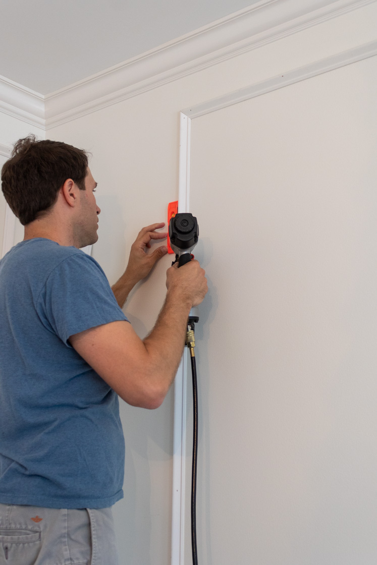 Nailing wainscoting trim to secure to wall.