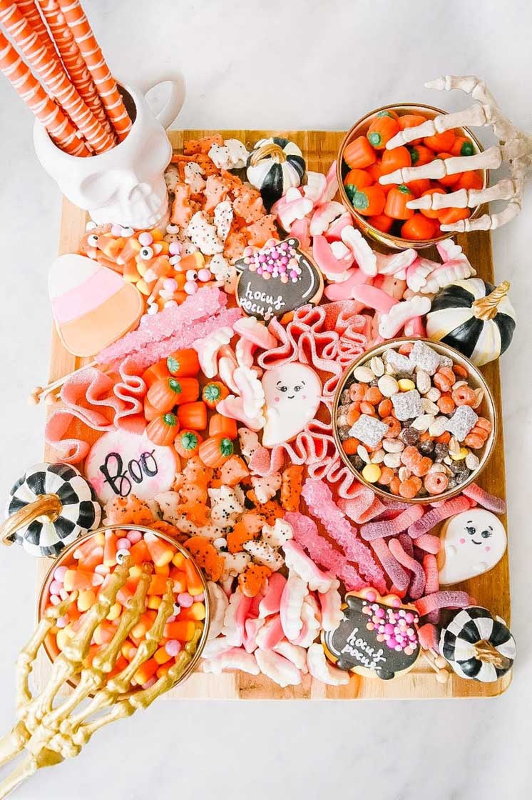 Perfectly pink Halloween themed snack board composed of cookies and candy