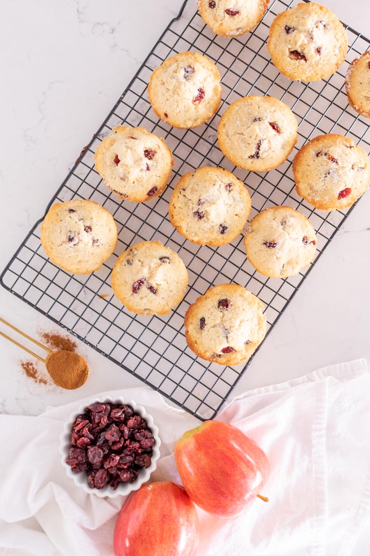 a batch of cranberry apple muffins in a cooling rack