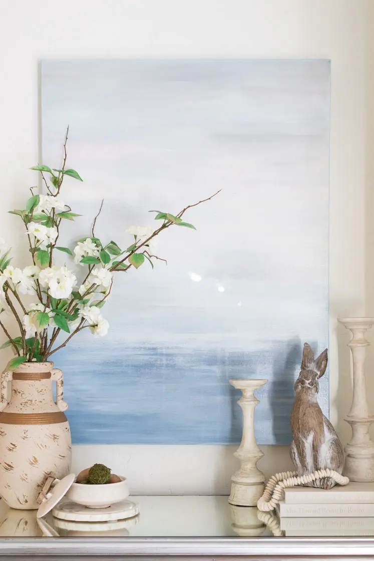 mirrored side board decked out for Easter with neutral vessels and Easter rabbit.