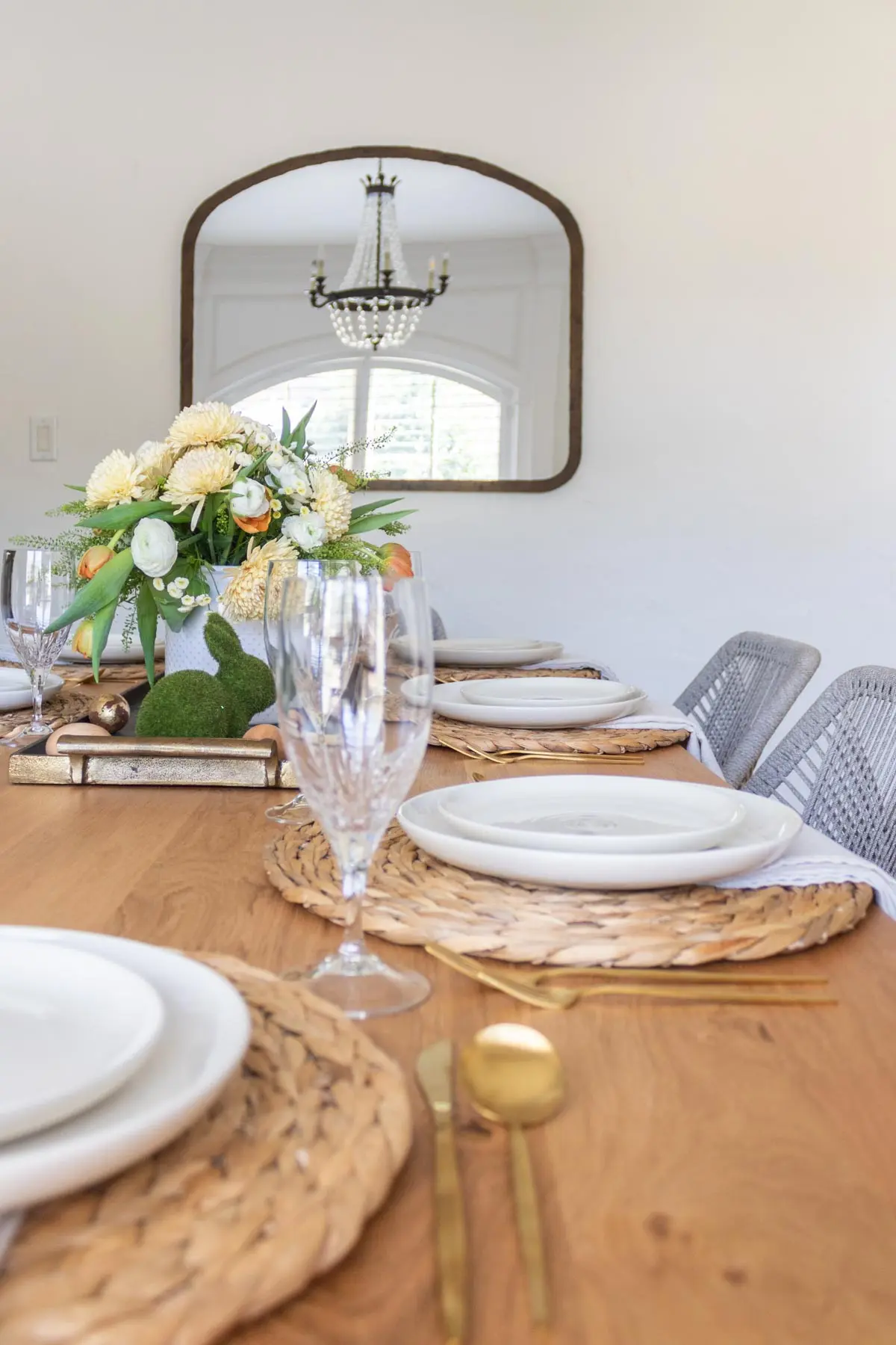 side view of easter table with green moss bunny, floral centerpiece and neutral dinnerware